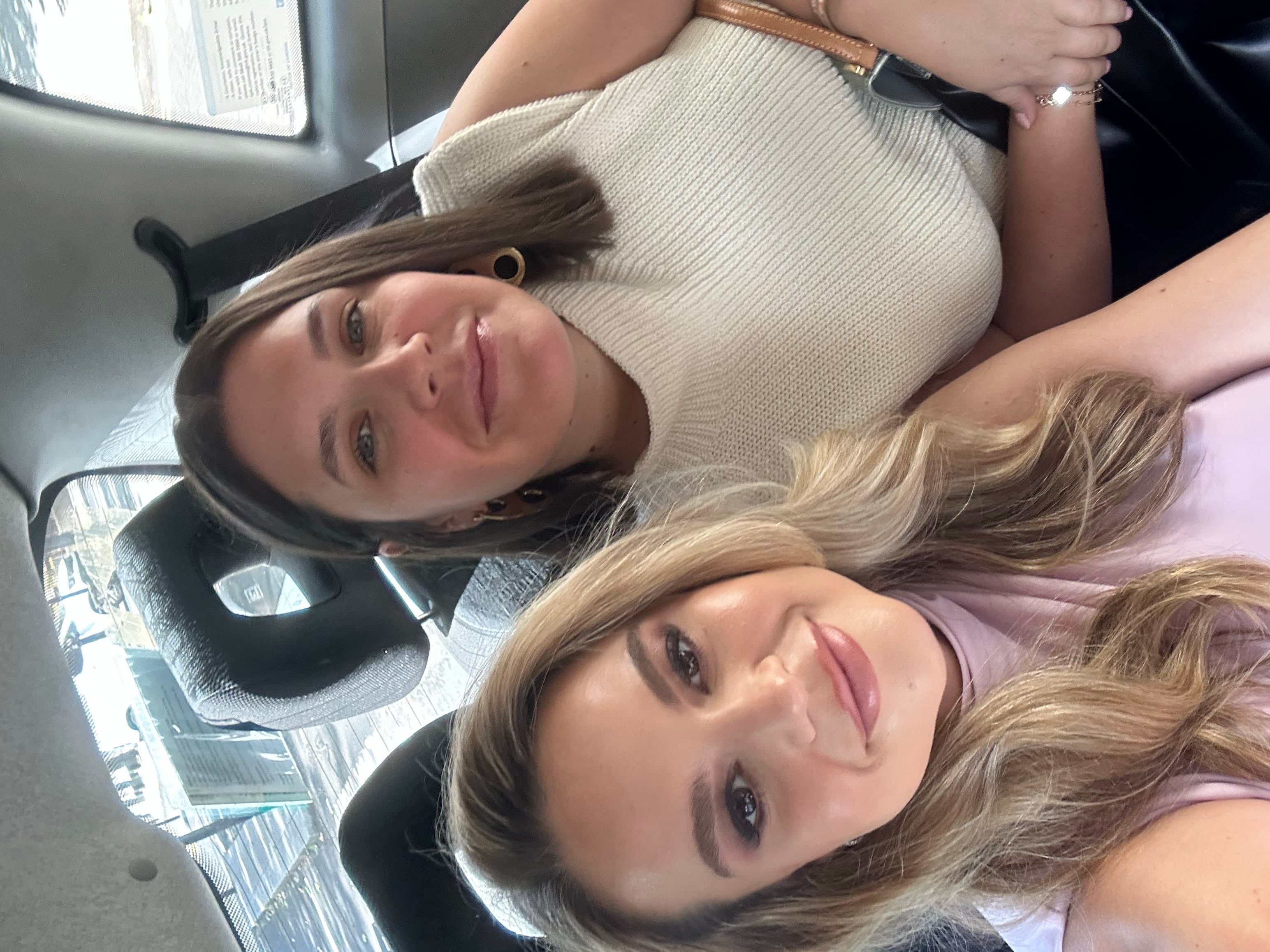 Aileen and Natalie taking a selfie together in a car