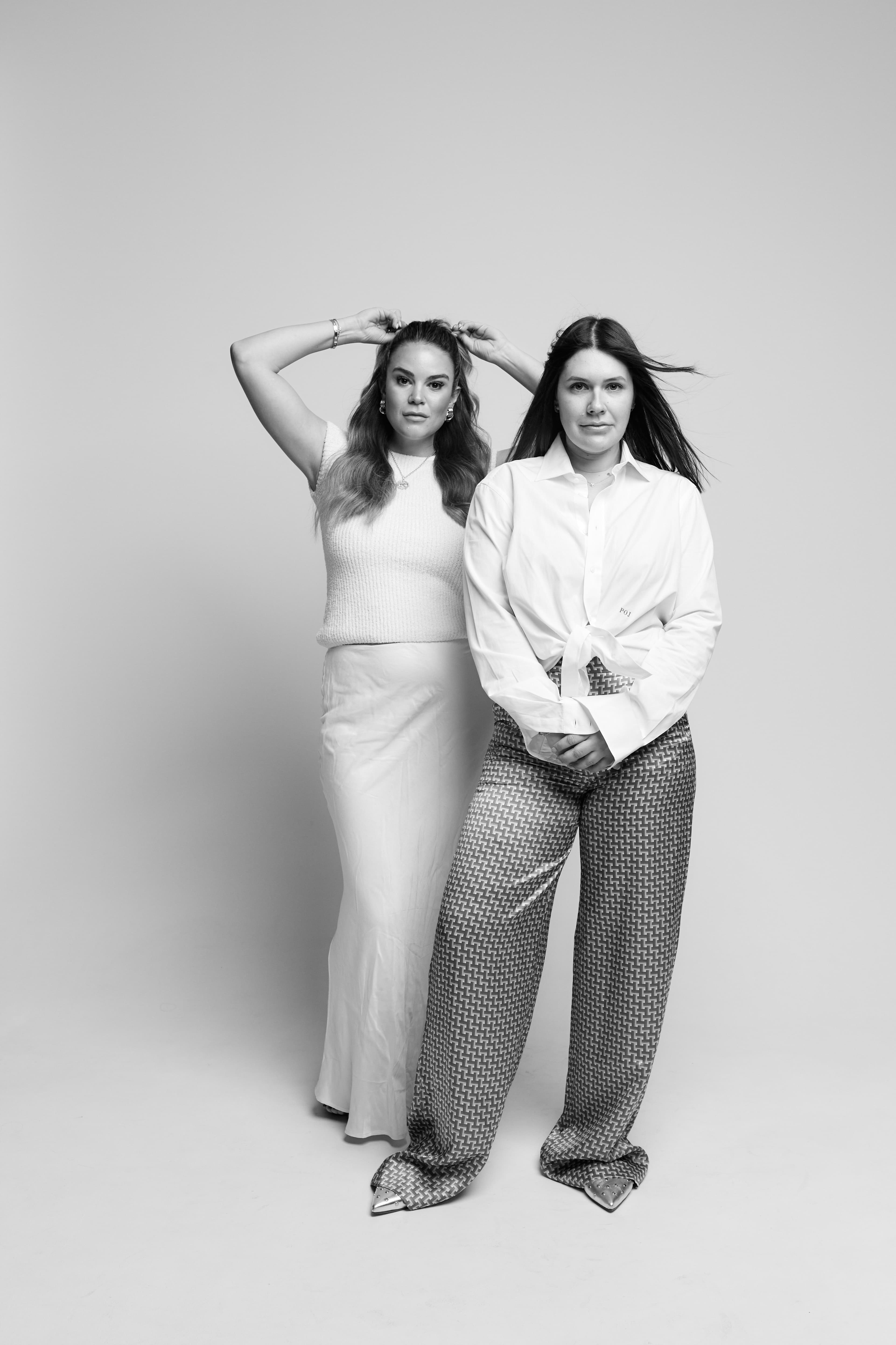 Aileen and Natalie, the founders, in a black-and-white studio portrait